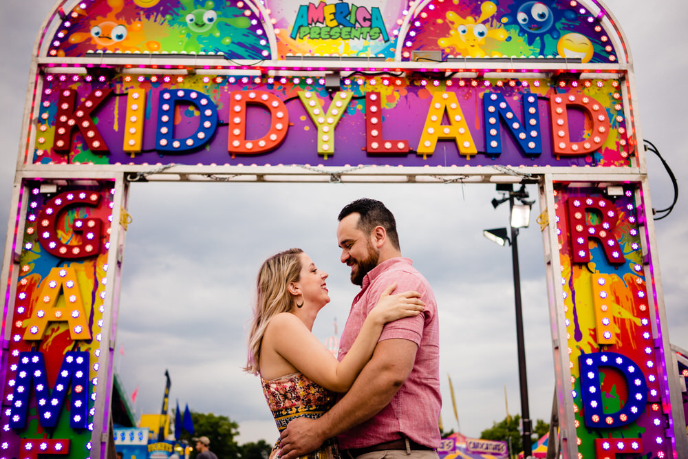 Bride and Groom smiling by the Kiddyland rides at the Ohio State Fair