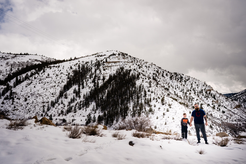 Planning your epic Utah family vacation. Dad and son stand in snowy Utah outside of Moab Utah