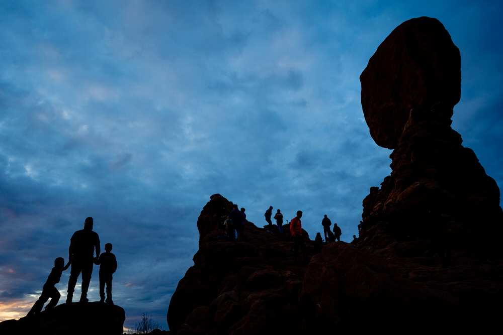 Planning your epic Utah family vacation. Family play on the trails of Arches National Park.