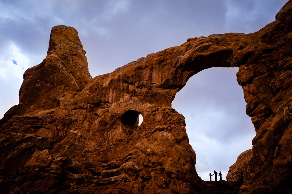 Planning your epic Utah family vacation. Family play on the trails of Arches National Park.