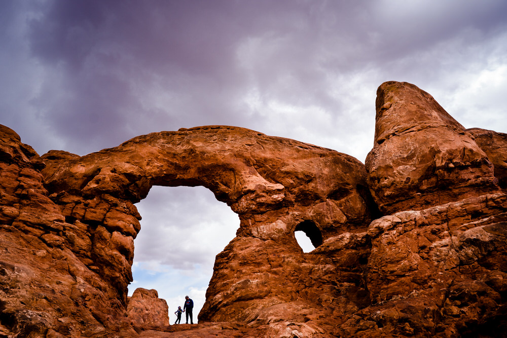 Planning your epic Utah family vacation. Family play on the trails of Arches National Park.