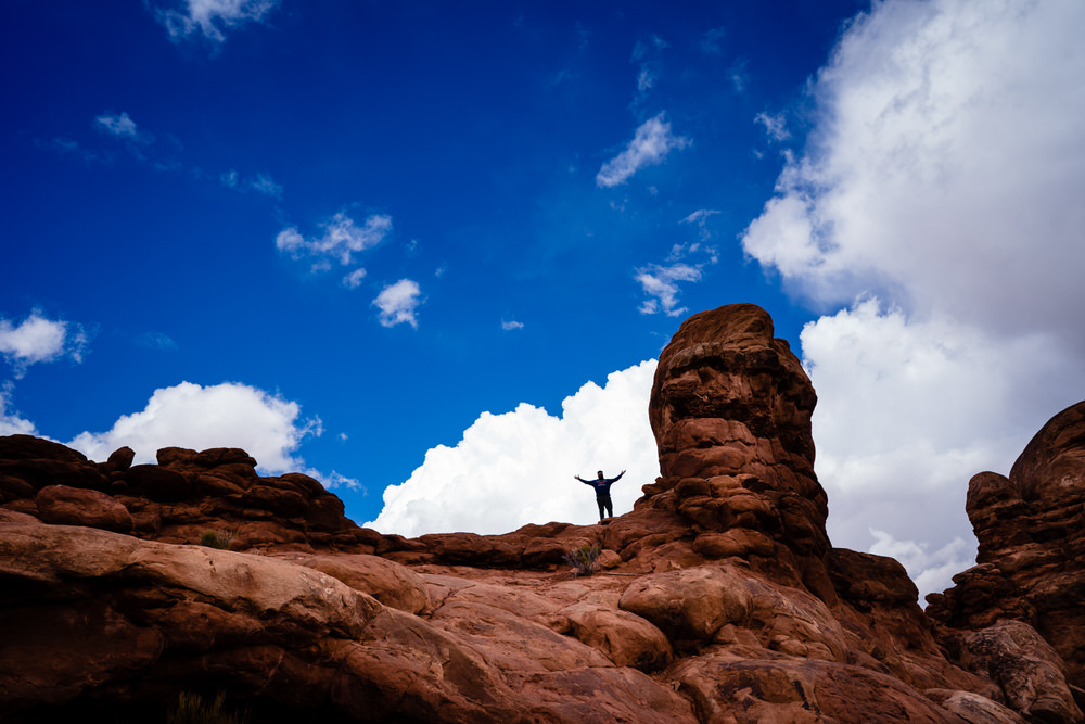 Planning your epic Utah family vacation. Family play on the trails of Arches National Park.