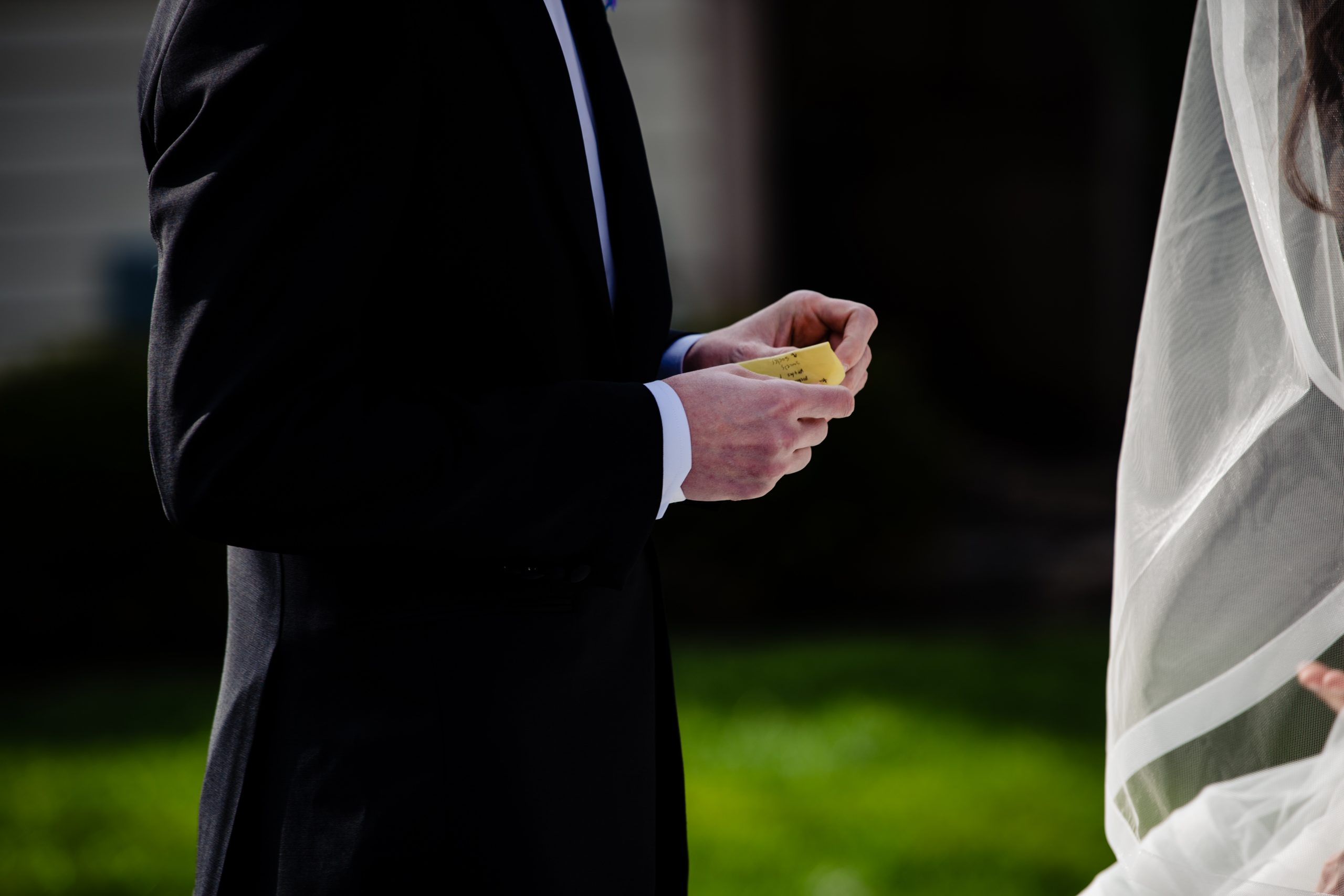 A groom holds his vows as he listens to his bride reads her during a COVID ceremony in Columbus, Ohio.