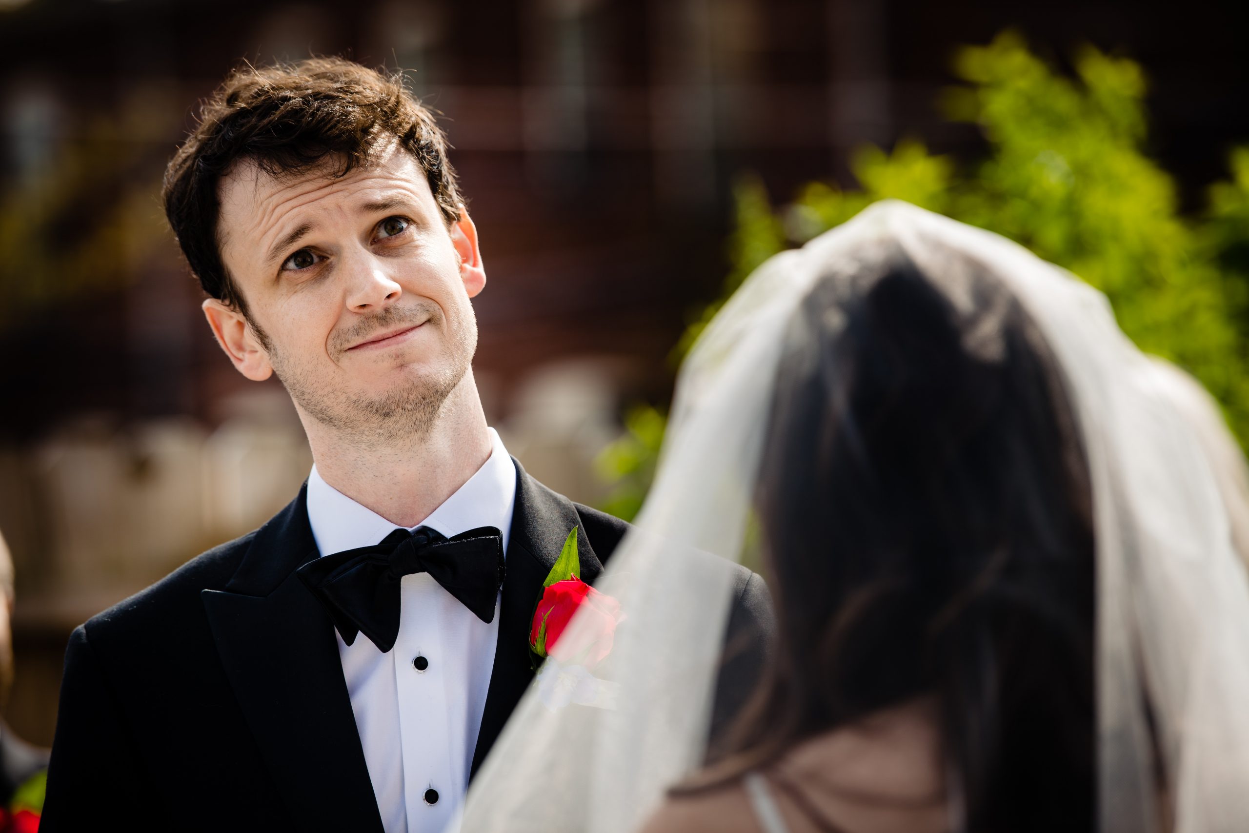 A groom listens to his bride read her vows during a COVID ceremony in Columbus, Ohio