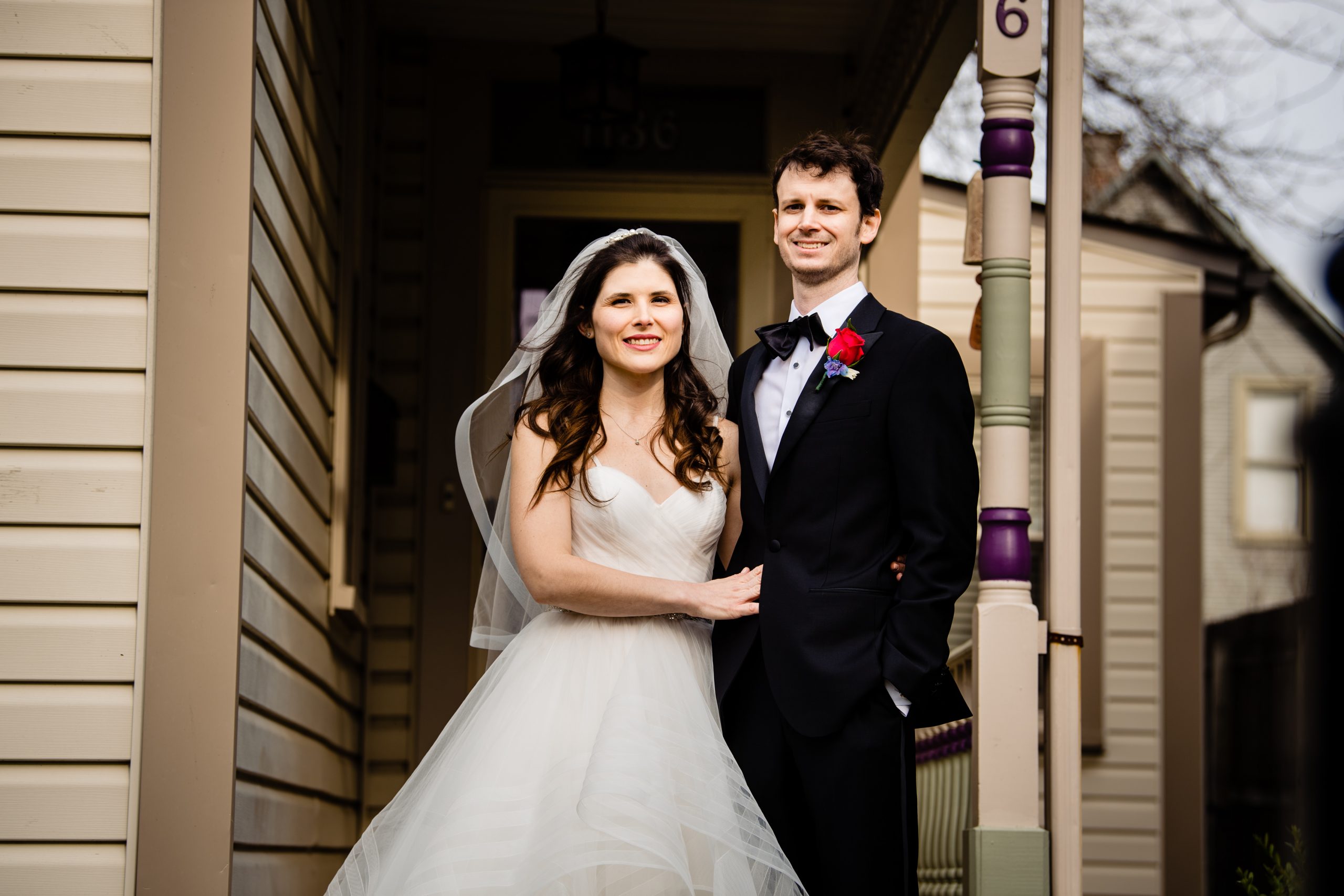 A bride and groom outside of their home after their COVID ceremony.